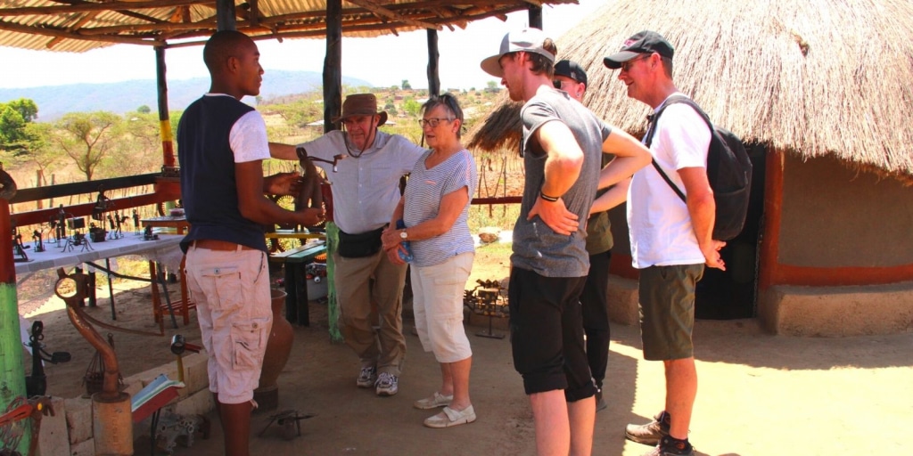 Pilato Bulala in his outside gallery talking to Alexandra's Africa guests about his work