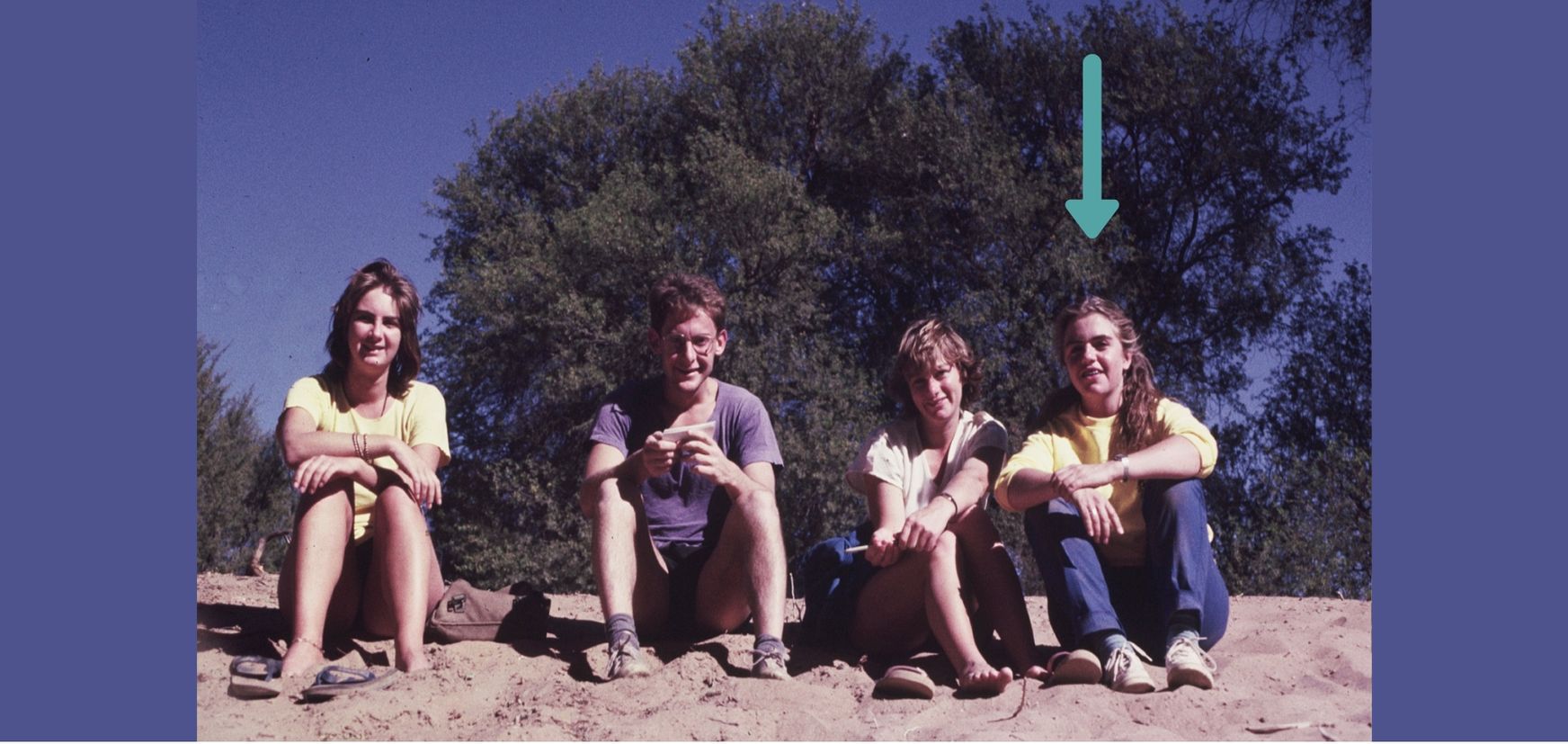 Alexandra as a young research sitting on a sand dune in Namibia with research colleagues