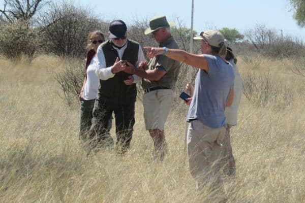 Conservation Experience Workers in the Kalahari in a group discussing at their approach to Vegetation Survey