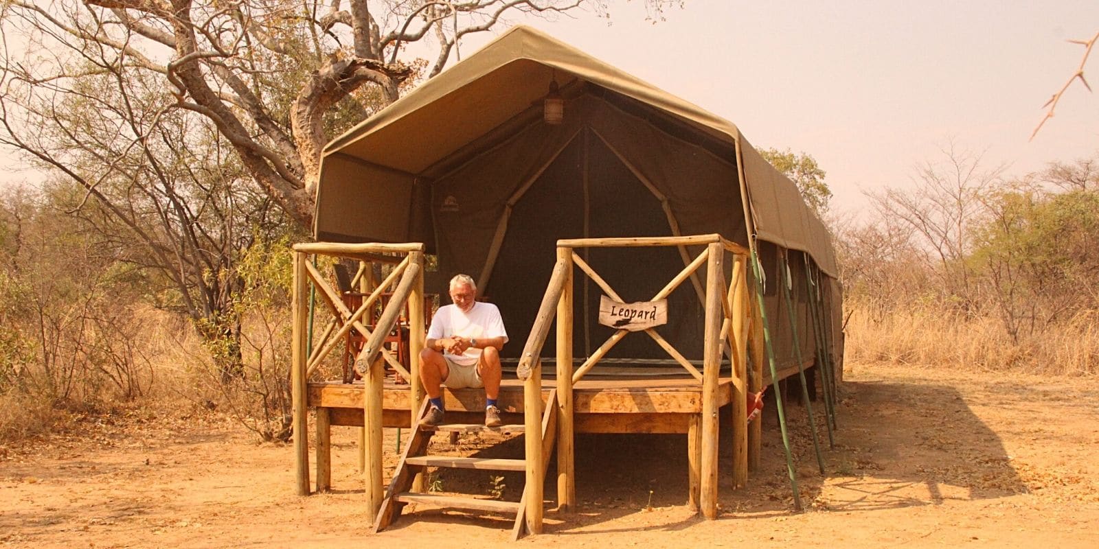 Alexandra's Africa Guest relaxed on steps of tented en-suite accommodation
