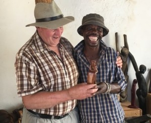 Lucky Ntimani standing with Alexandras Africa guest with arm around Lucky in Lucky's Gallery of wood carvings