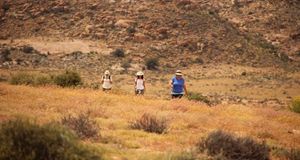 Three Women walking in wild flower meadow in Namaqualand