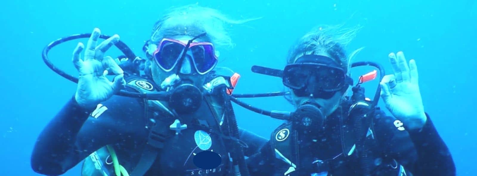 Scuba Diving Buddies Scuba Diving Buddies - Close up of faces of two Women under water Scuba Diving - showing the universal all OK sign