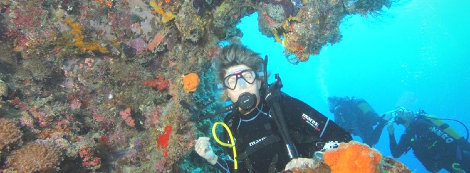 Scuba Diving in Madagascar Scuba Diving in Madagascar - Picture of Female Scuba diver underwater with beautifully colour coral reef behind her